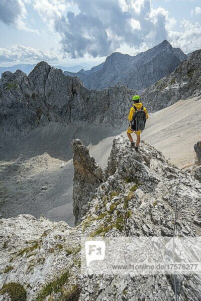 Wanderer auf Felsvorsprung  Wanderweg zur Lamsenspitze  hinten Kar und felsige Berggipfel mit Mitterkarlspitze  Karwendelgebirge  Alpenpark Karwendel  Tirol  Österreich  Europa