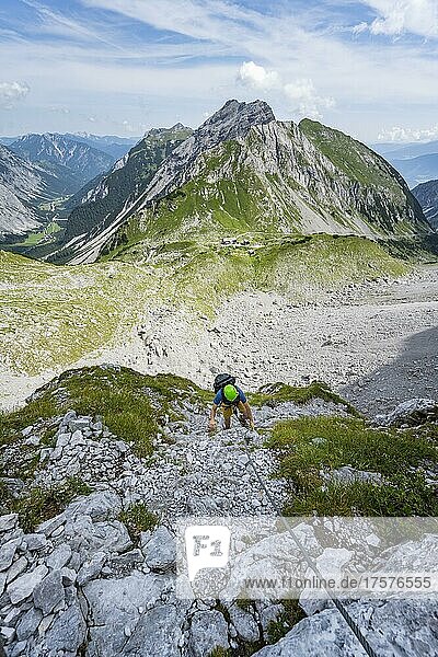 Young man climbing in via ferrata  via ferrata Brudertunnel  hiking trail to Lamsenspitze  Below Kessel with Lamsenjochhütte  Karwendel Mountains  Alpenpark Karwendel  Tyrol  Austria  Europe