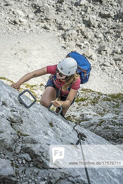 Young woman climbing a steep rock face  Lamsenspitze via ferrata  Tyrol  Austria  Europe