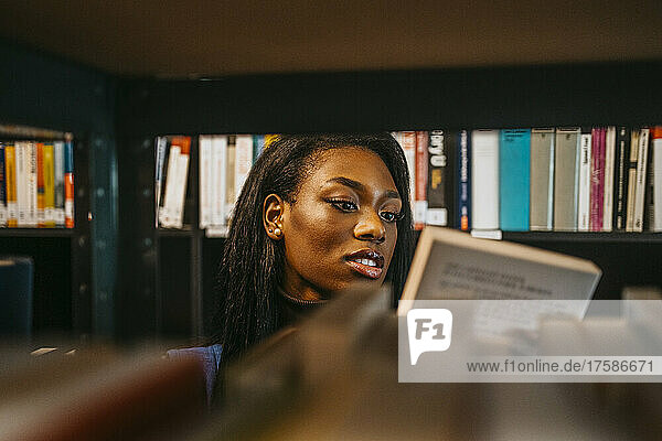 Junge Frau sucht ein Buch in der Bibliothek der Universität