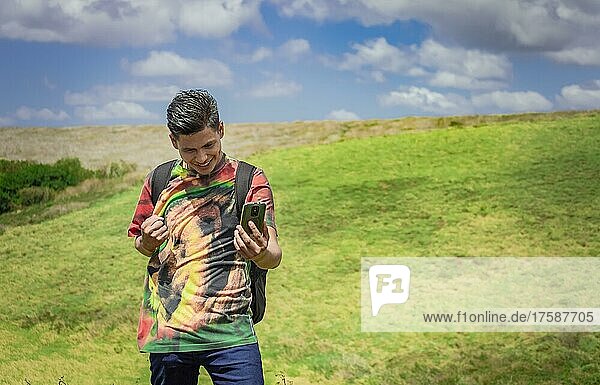Fröhlicher Mann beim Fotografieren im Feld  junger Mann beim Fotografieren im Feld mit seinem Handy