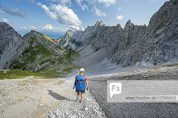 Hiker descends over a boulder field to the Lamsenjochhütte  Karwendel Mountains  Tyrol  Austria  Europe