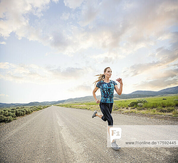 United States  Utah  Cedar Fort  Woman jogging on road in desert landscape