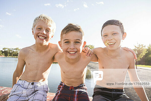 Portrait of smiling shirtless boys (8-9) by river