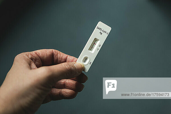 Hand of woman holding rapid diagnostic test for COVID-19