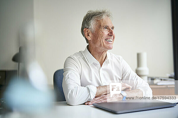 Thoughtful businessman with laptop in studio