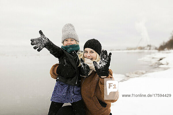 Cheerful mother and daughter enjoying in snow
