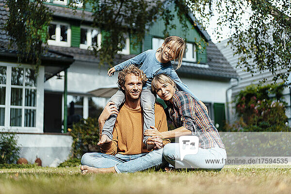 Lächelnder Mann und Frau mit Sohn vor dem Haus