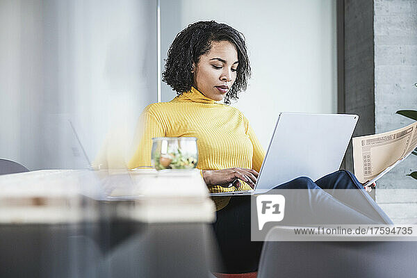 Young businesswoman using laptop at work place