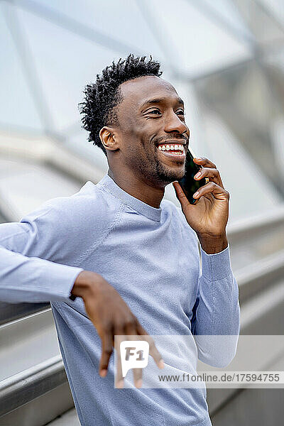 Happy man with black hair talking on smart phone