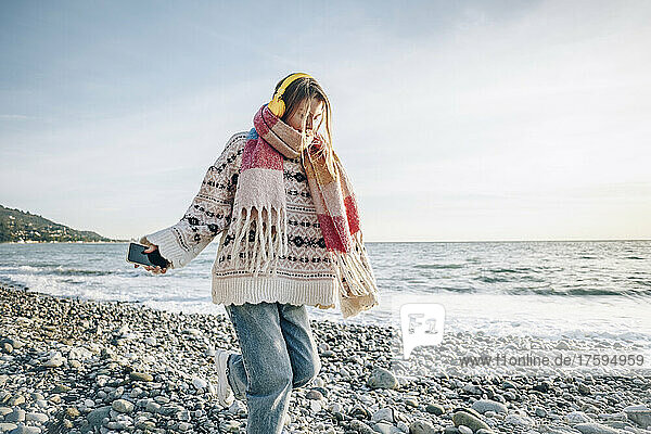 Girl with headphones and smart phone enjoying vacation at beach  Gagra  Abkhazia