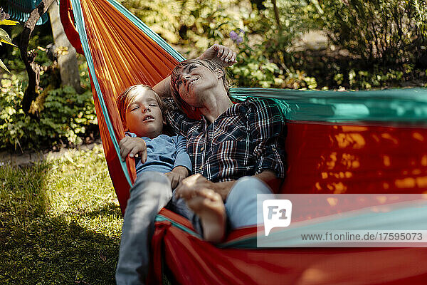 Mother day dreaming by son sleeping in hammock