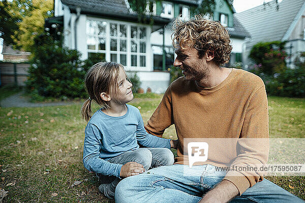 Smiling son and father in garden outside house