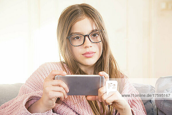 Girl with smart phone in living room at home