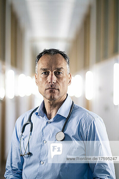 Serious mature doctor at corridor in hospital