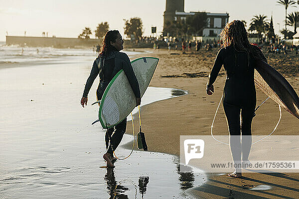 Female surfers with surfboards walking together on beach  Gran Canaria  Canary Islands