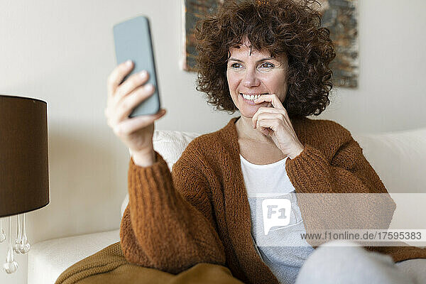Happy woman on video call through smart phone at home