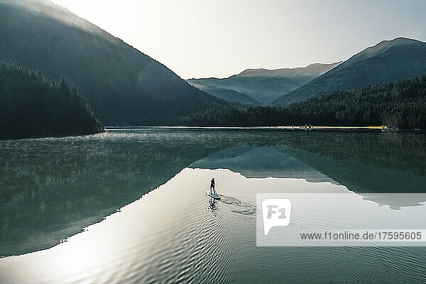 Woman paddleboarding on Sylvenstein lake  Bad Tolz  Bavaria  Germany