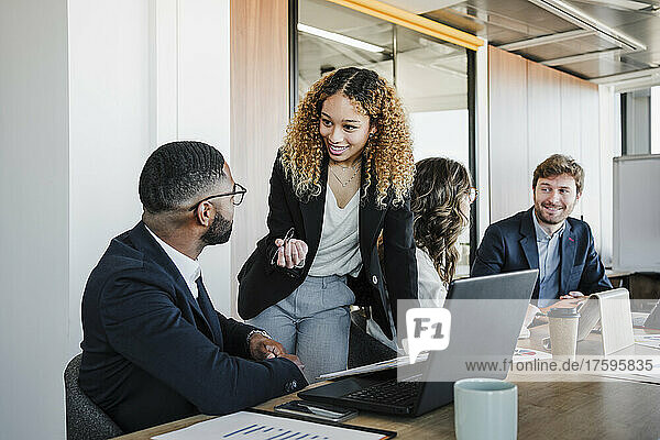 Young businesswoman discussing strategy with businessman in office