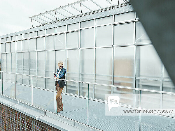 Contemplative businesswoman standing on balcony at office