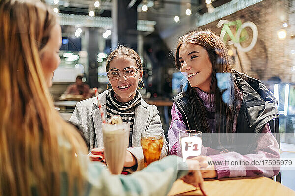 Lächelnde Freunde  die im Café etwas trinken