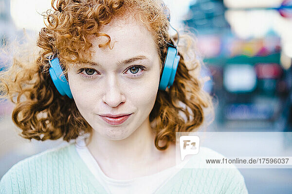 Young woman listening music through headphones