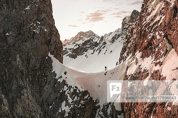 Tourist walking on snow covered mountain at sunrise  Ehrwald  Tirol  Austria