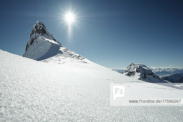 Die Sonne scheint über dem schneebedeckten Gipfel im Rofangebirge