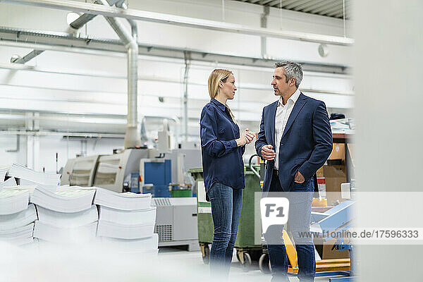 Blond businesswoman discussing ideas with colleague in industry