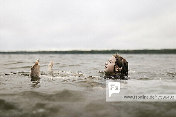 Girl floating in lake water