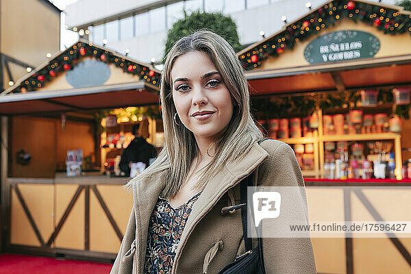 Blonde Frau mit Jacke auf dem Weihnachtsmarkt