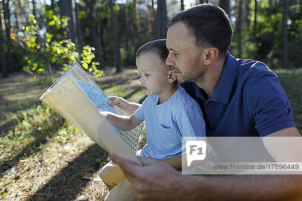 Vater und Sohn lesen Karte im Wald