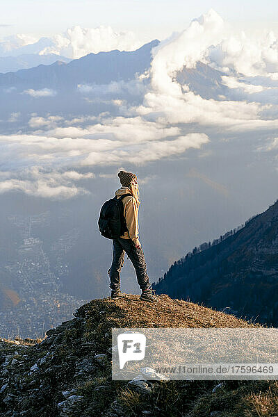 Young woman with backpack standing on cliff at Caucasus Nature Reserve in Sochi  Russia