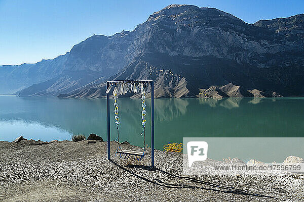 Empty swing overlooking mountain lake
