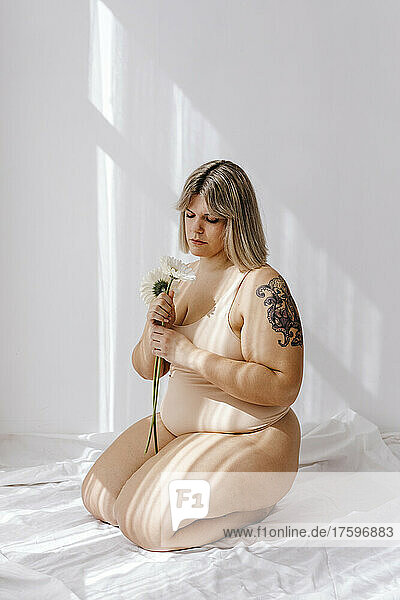 Plus size woman with blond hair looking at flowers