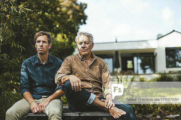 Vater und Sohn sitzen zusammen im Hinterhof