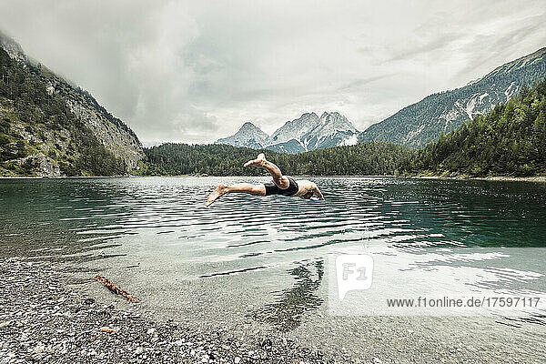 Man diving in Blindsee lake by Mieming Range  Tirol  Austria