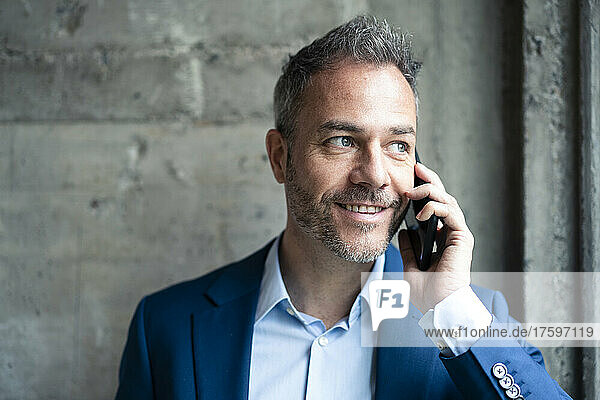 Lächelnder Geschäftsmann  der am Smartphone spricht