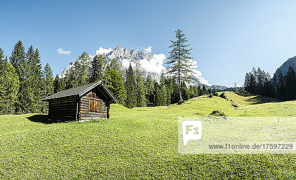 Barn standing in alpine meadow with Zugspitze mountain in background