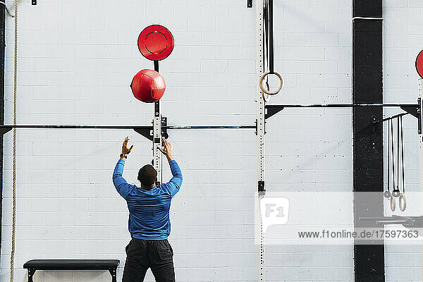 Sportsman exercising with medicine ball in gym