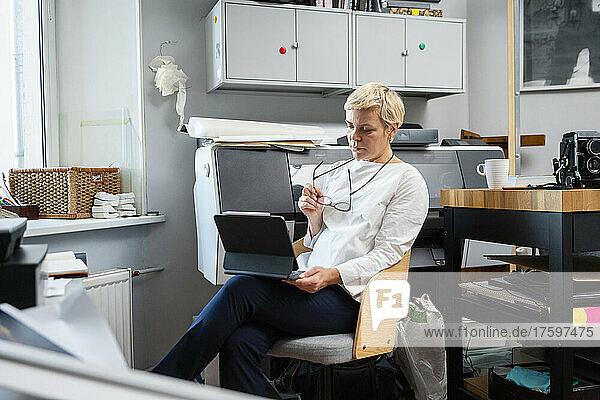 Woman sitting with tablet PC in office