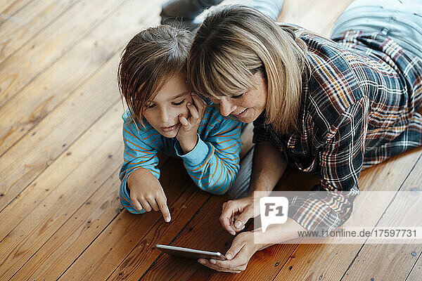 Boy and mother talking over digital tablet at home