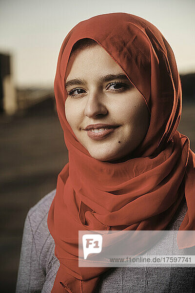 Smiling young woman wearing red hijab
