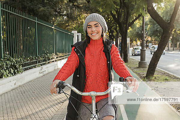 Lächelnde schöne Frau mit Fahrrad unterwegs