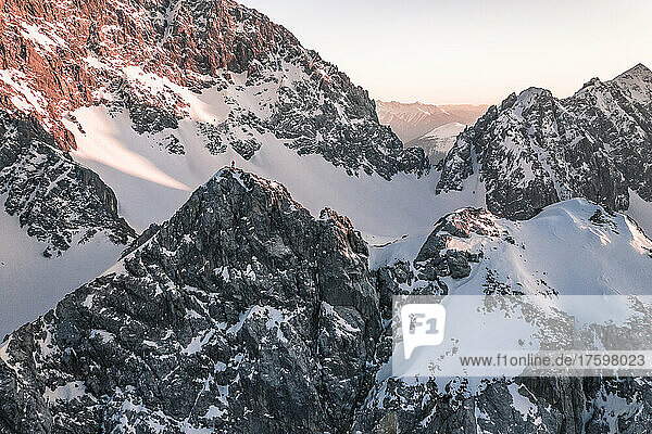 Adventurous man standing on snow covered mountain at sunset  Vorderer Tajakopf  Ehrwald  Tirol  Austria