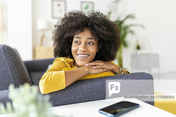 Happy thoughtful woman on sofa at home