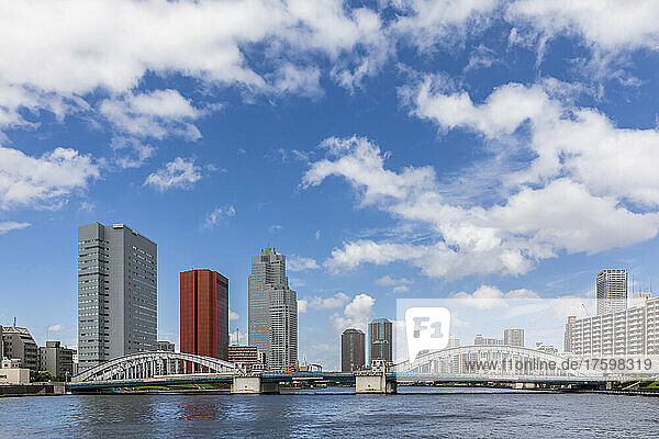 Japan  Kanto Region  Tokyo  Clouds over waterfront skyscrapers with Kachidoki Bridge in foreground