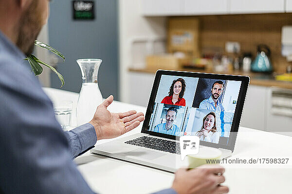 Businessman discussing with colleagues in web conference at home office