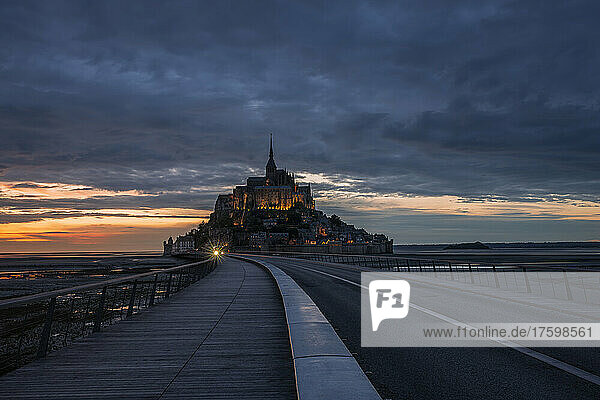 France  Normandy  Cloudy sky over bridge connecting Mont-Saint-Michel island at dusk