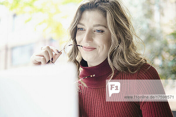 Smiling woman with laptop in cafe